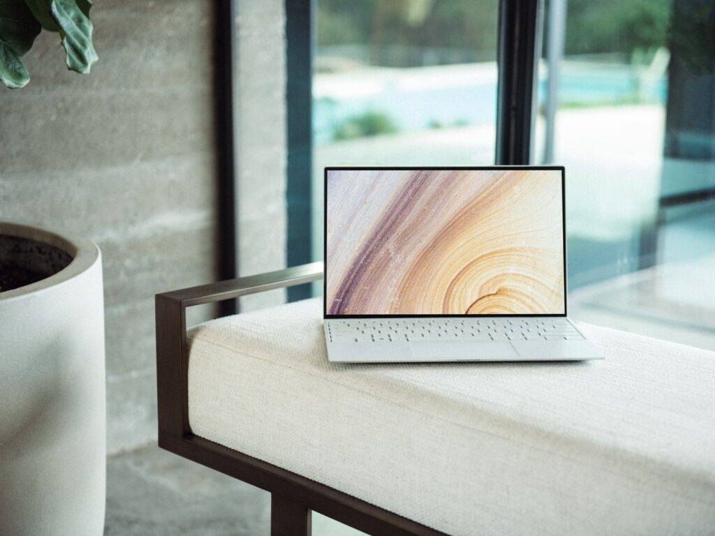 silver laptop on brown wooden table